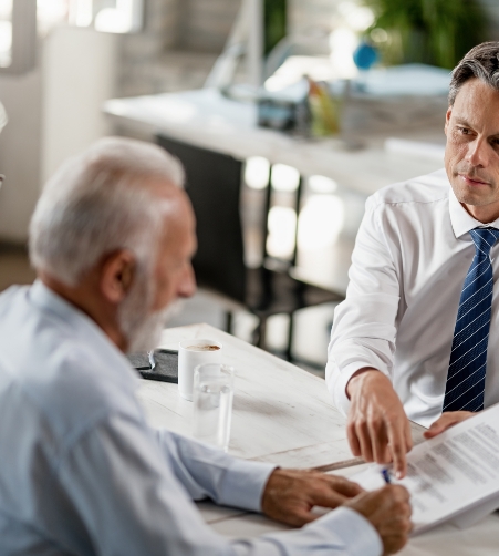 el-gerente-del-banco-tiene-una-reunion-con-una-pareja-de-ancianos-y-senala-el-lugar-donde-deben-firmar-el-contrato